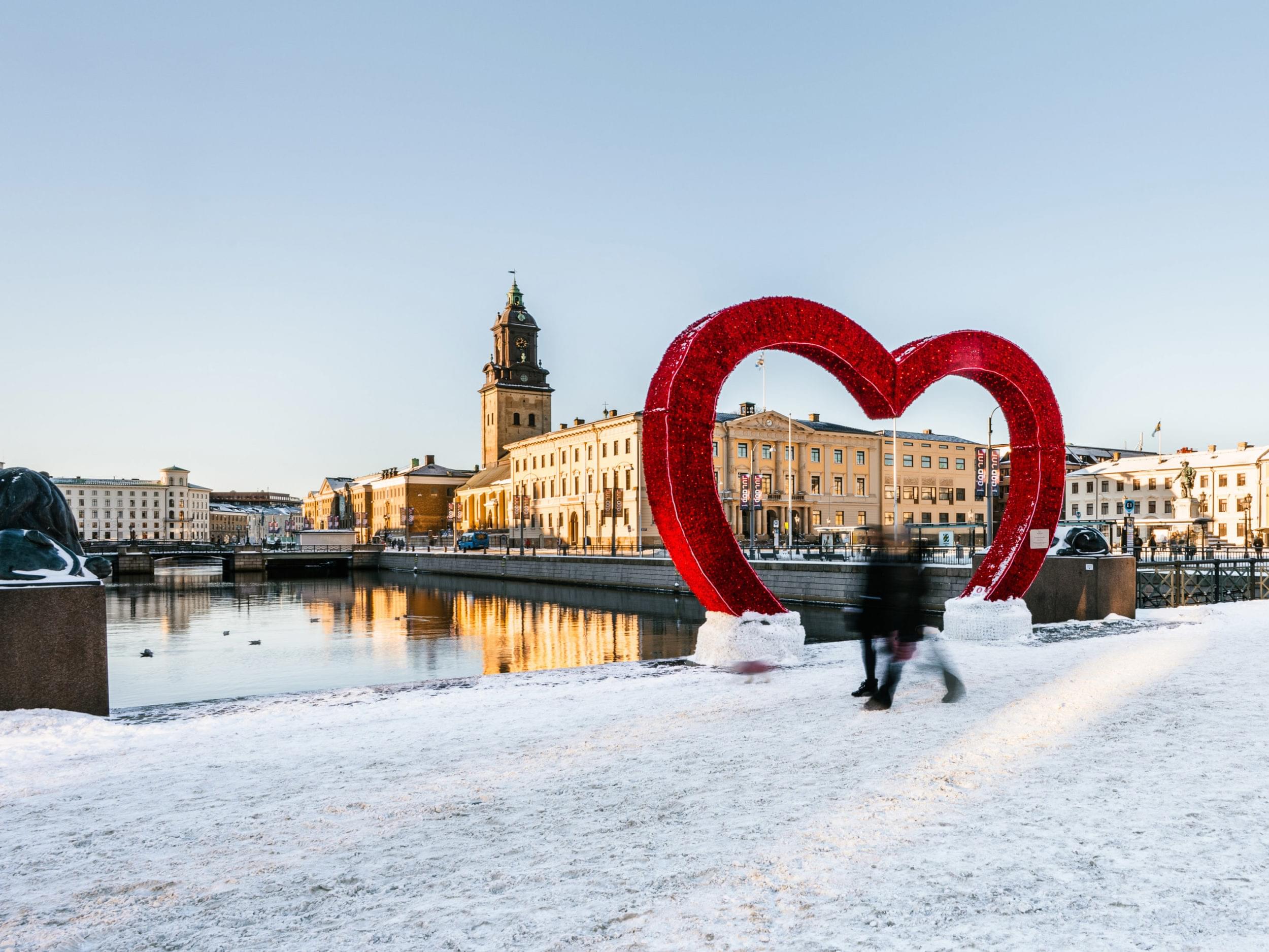 stadsvy i snö med stort rött hjärta i bakgrunden