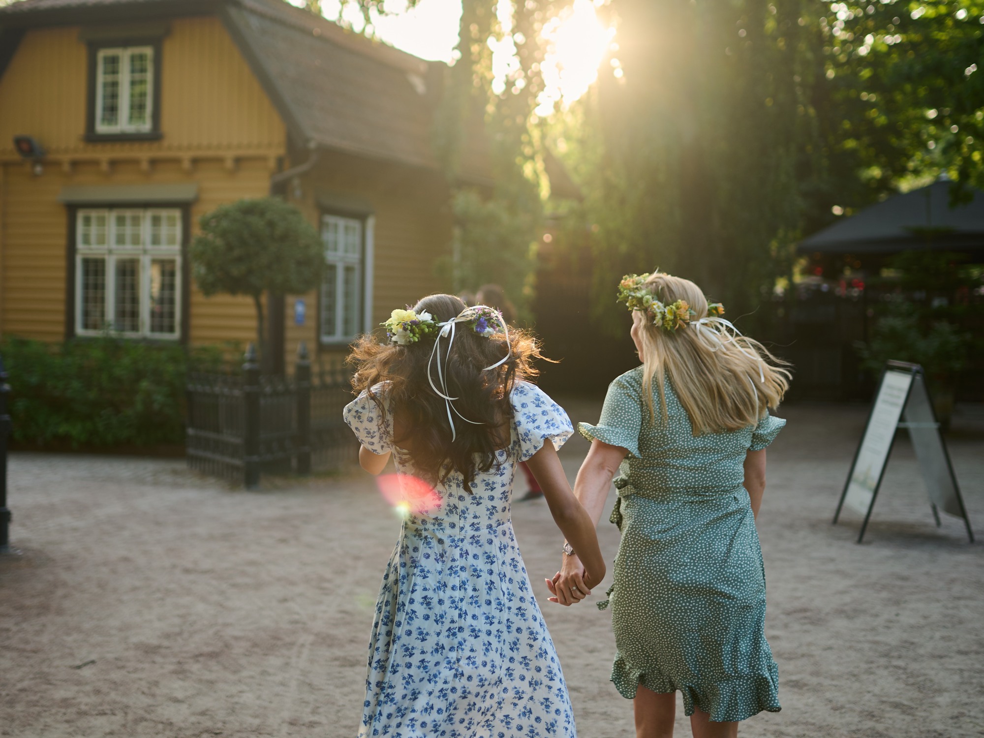 Two women with Swedish Midsummer flwer wreaths in Gothenburg.