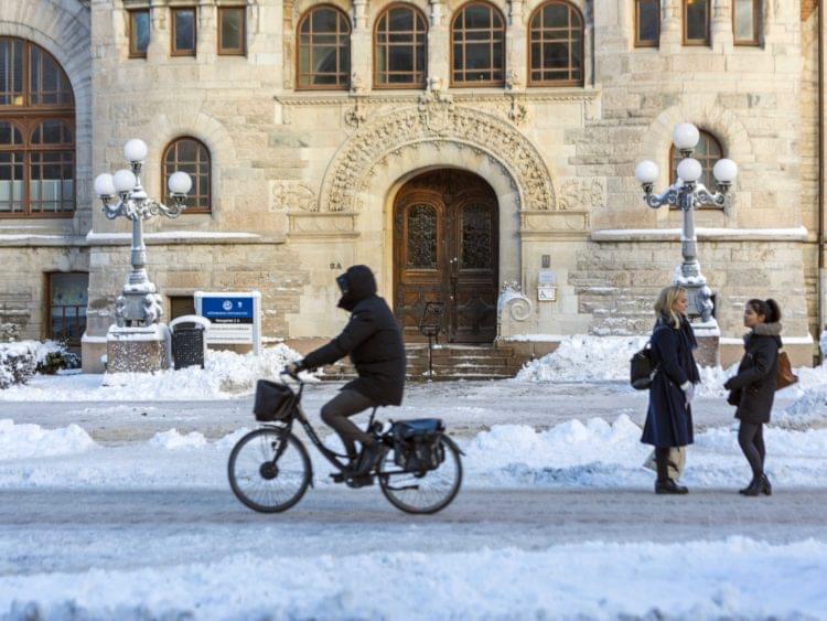 cyklist och två personer i stadsmiljö på vintern