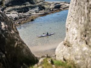 Kajak i en havsvik omgiven av klippor