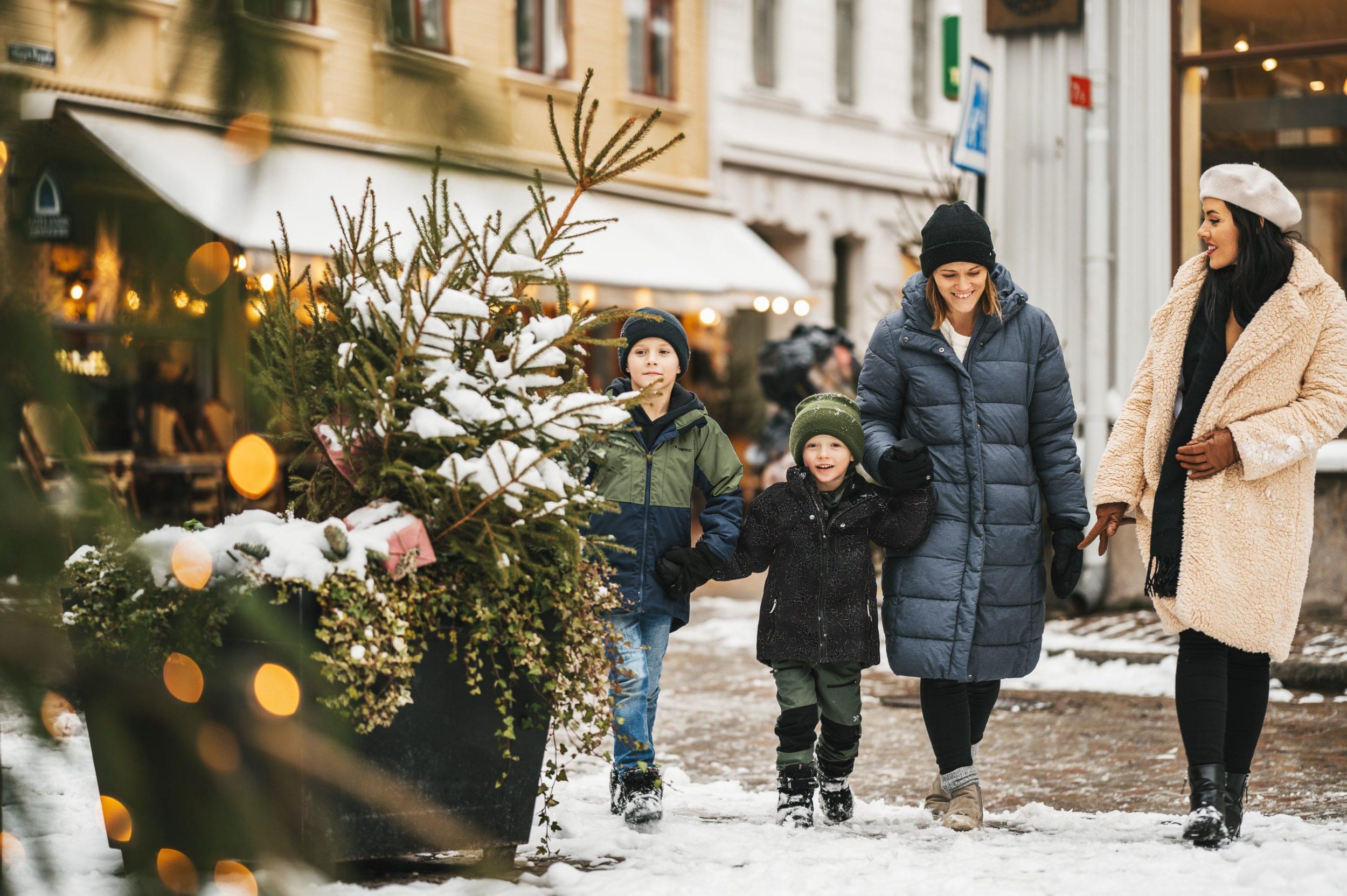 Två vuxna och två barn på promenad i ett vintrigt Göteborg.