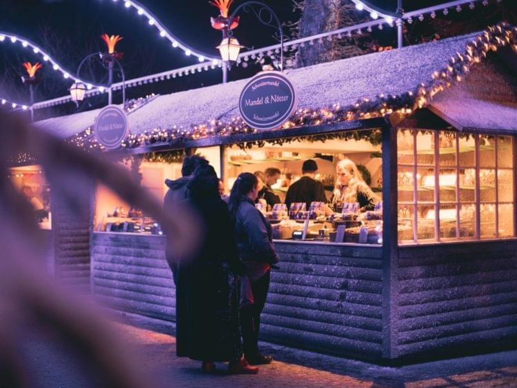 julmarknadsstånd med ljusslingor och snö