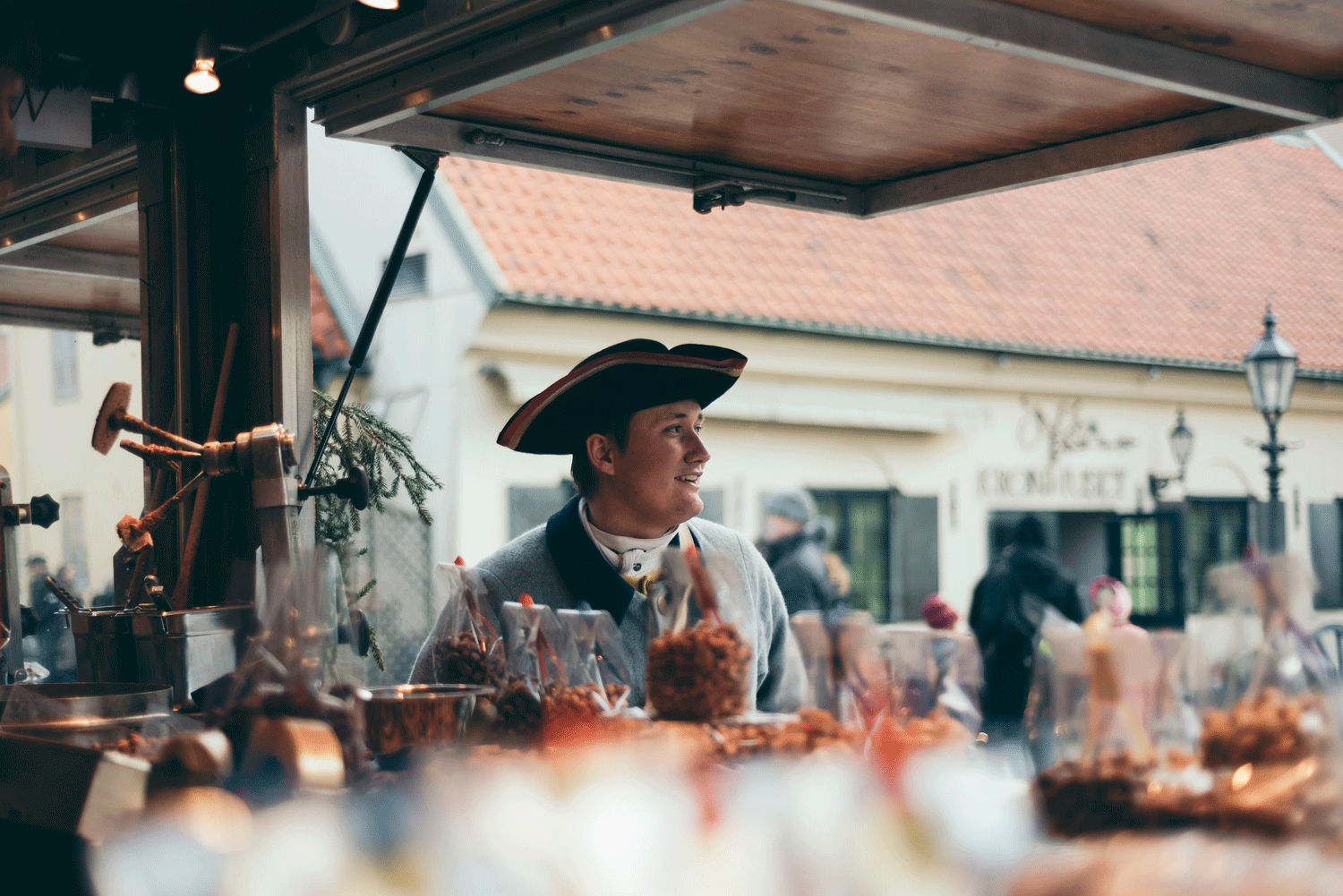 Vendor in old fashioned clothes in a candy stand.