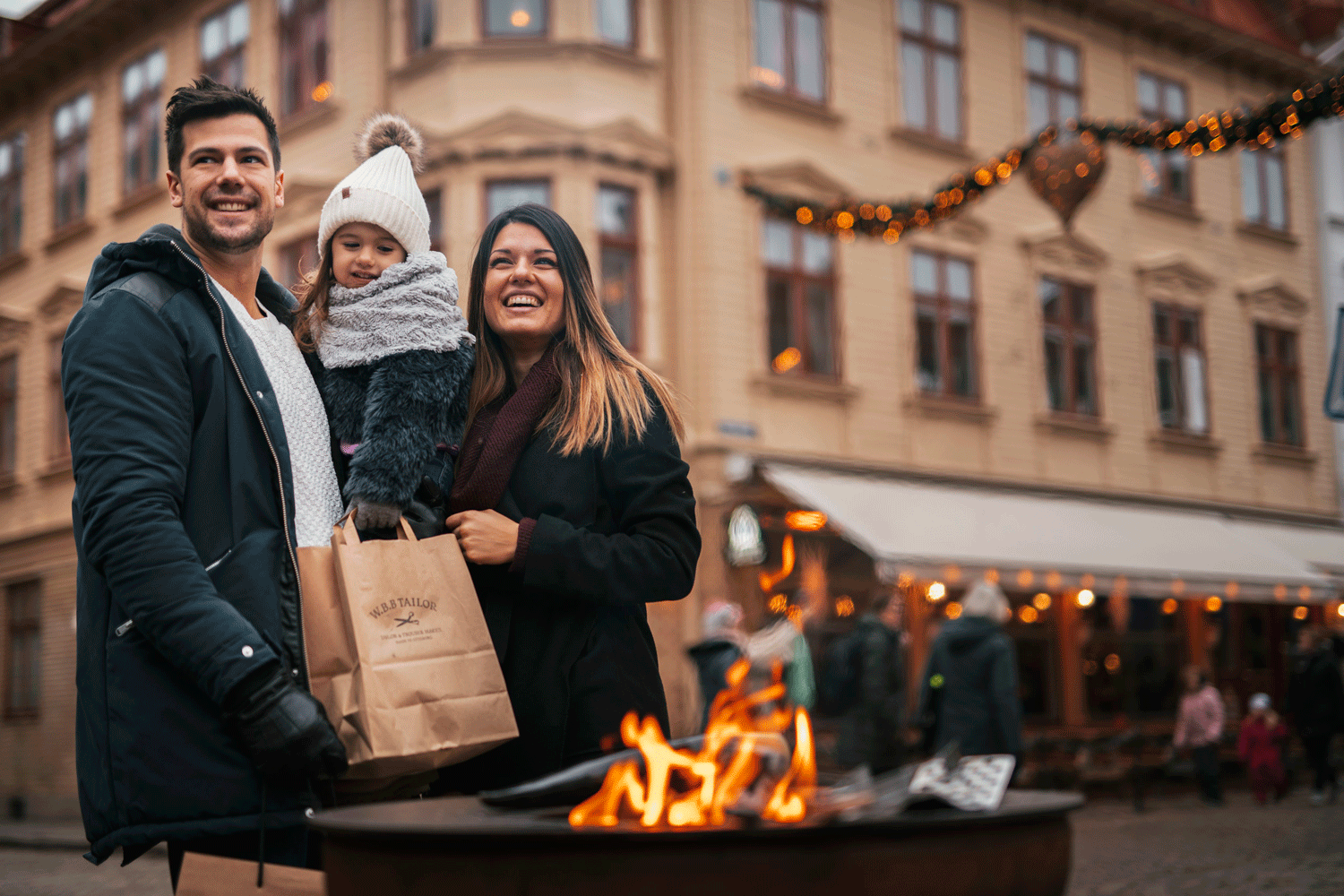 Two grown ups and a child enjoying christmas shopping.