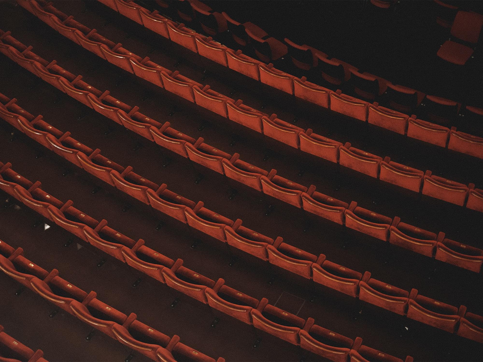 Röda stolar i rader fotograferade ovanifrån på Stora Teatern.