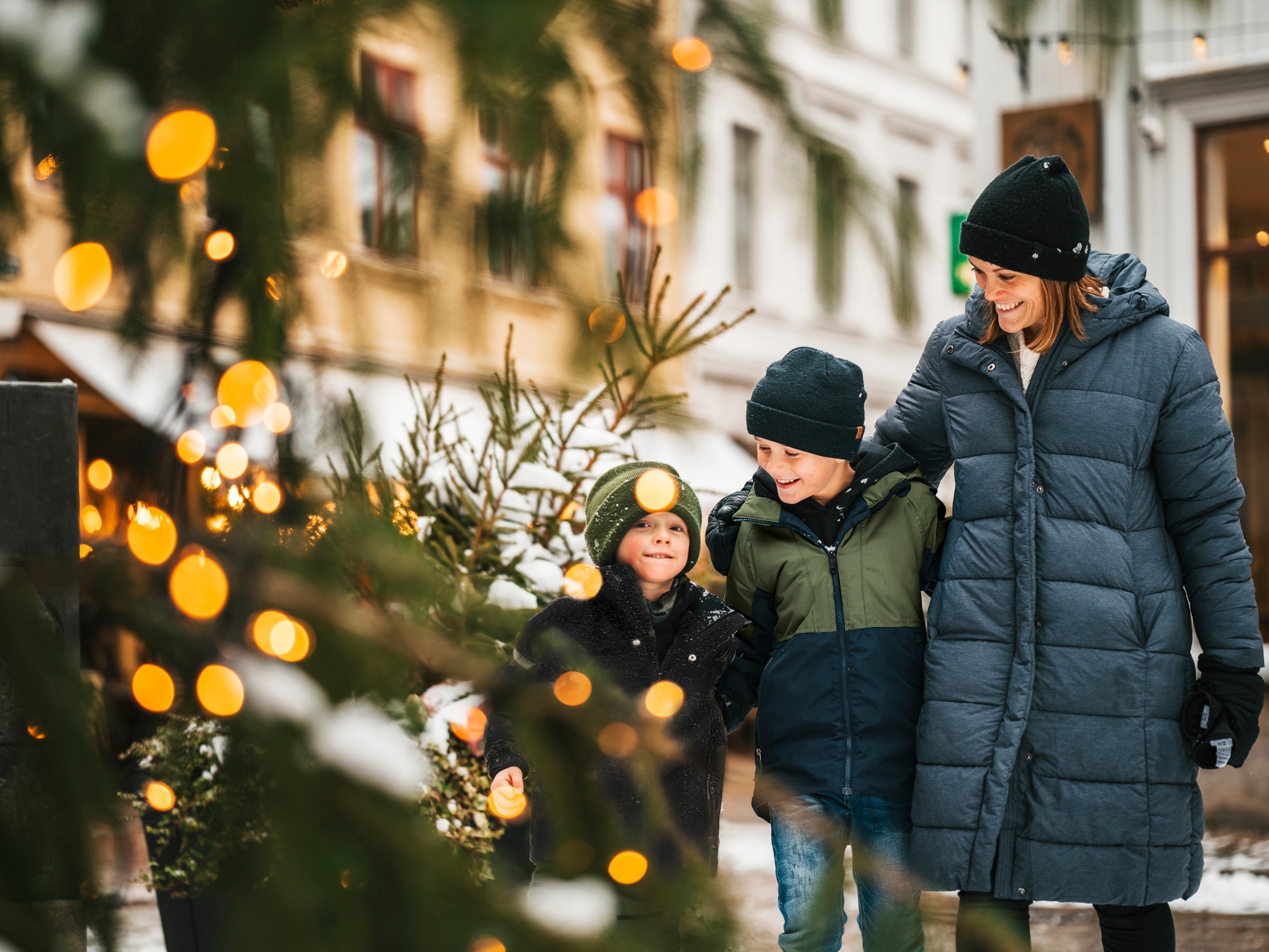 En vuxen och två barn går på en vintrig gata i Haga i Göteborg.