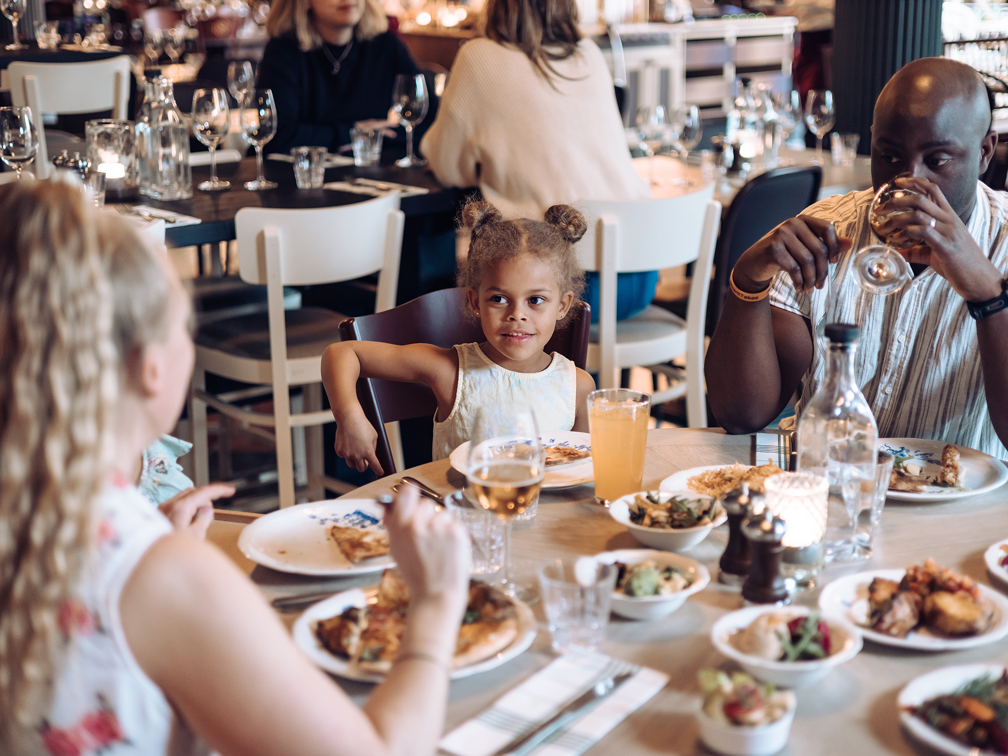 Två vuxna och ett barn äter middag på Liseberg Grand Curiosa i Göteborg.
