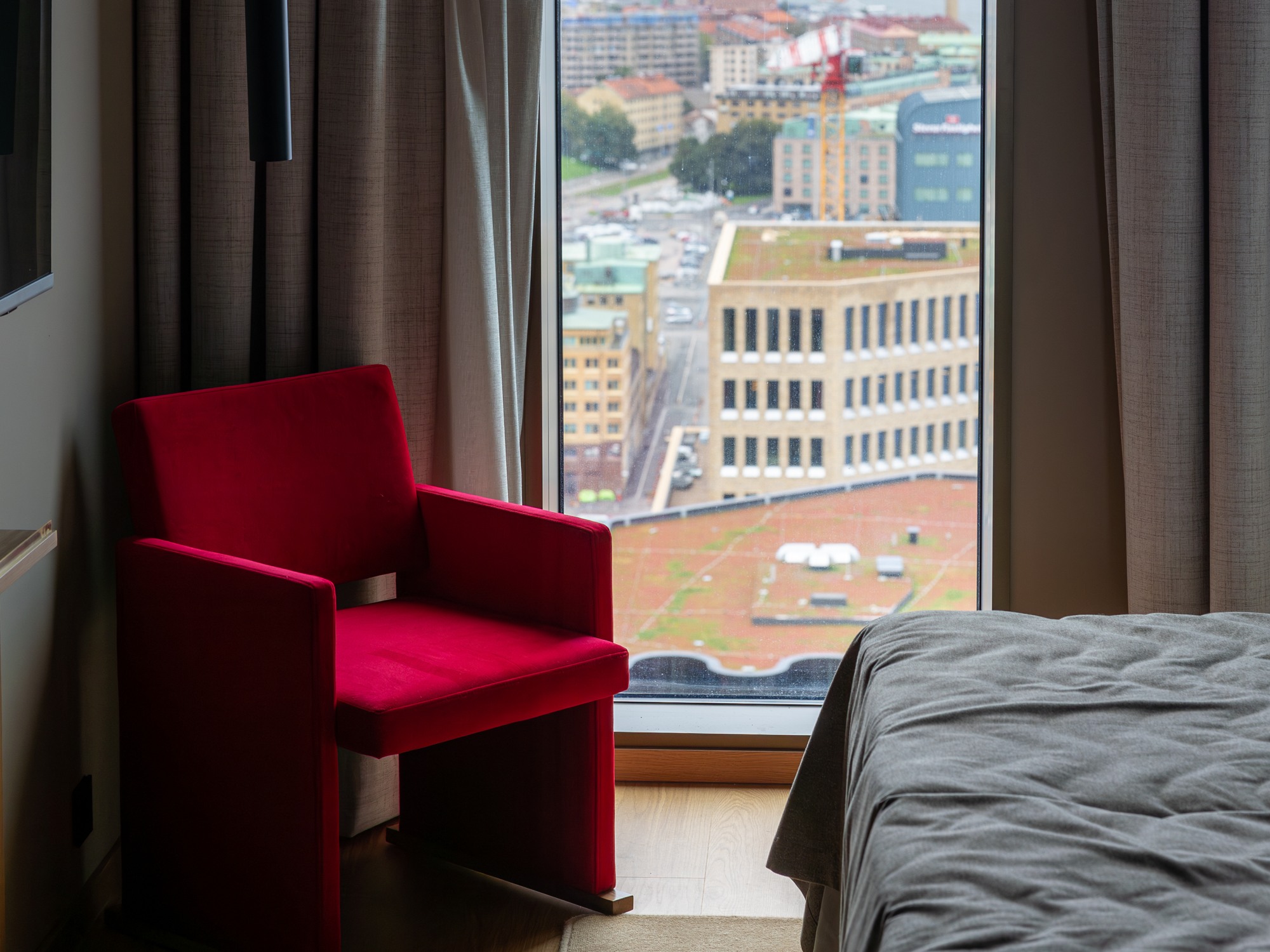 Fåtölj och säng i ett hotellrum på Draken i Göteborg.