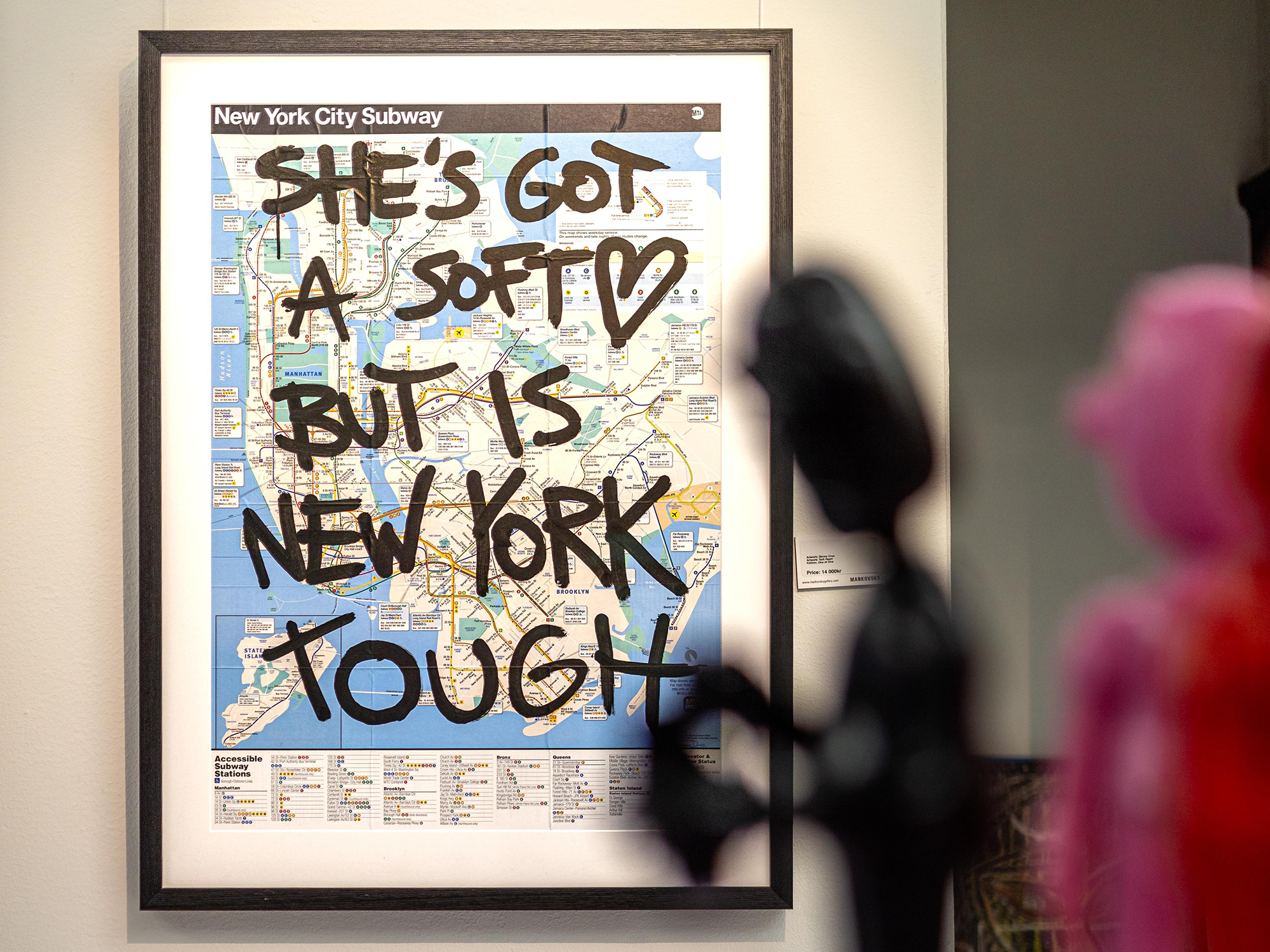 A poster of the subway map in New York with the text "she's got a soft heart but it is New York tough" written on top, like a graffiti