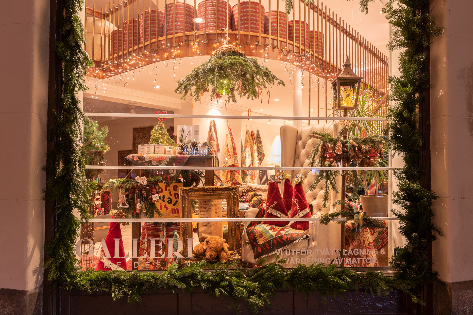 Utsikt till en inredningsbutik där fönstret är dekorerat med trädgrenar. Inuti kan vi se olika dekorationer mestadels av julsäsongen.