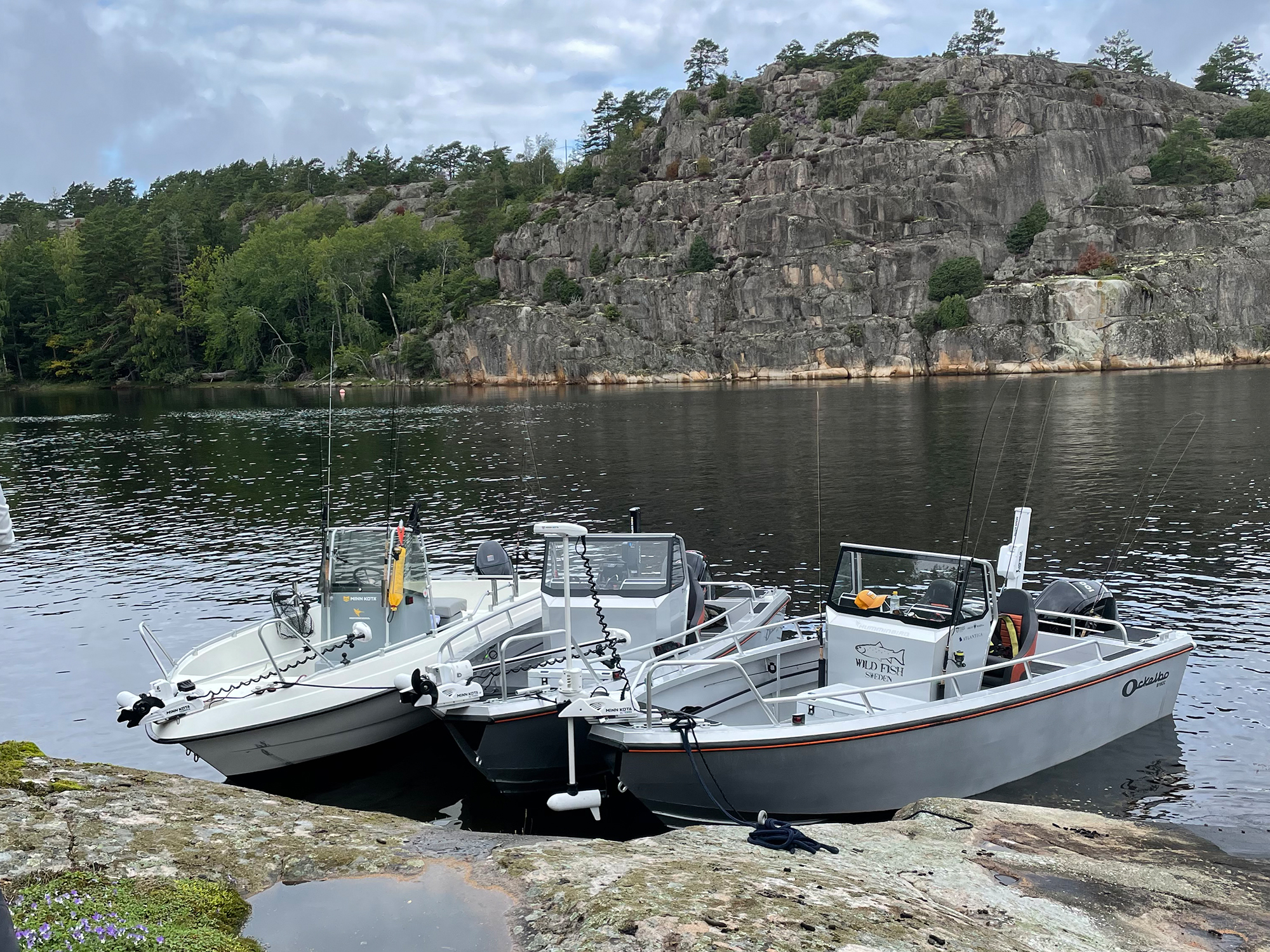Tre båtar förtöjda vid en klippa i havet utanför Göteborg.