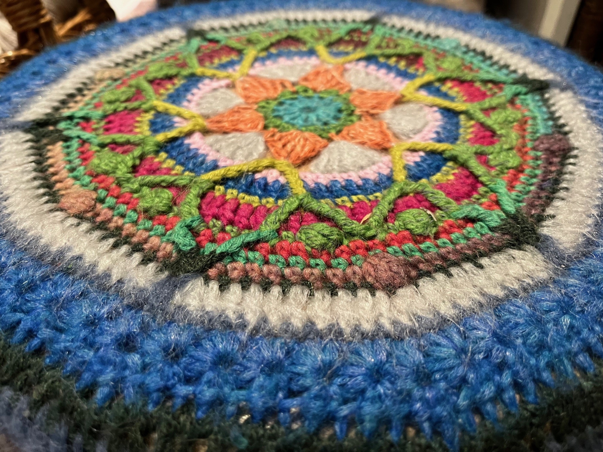 A colourful round piece of fabric made of yarn.