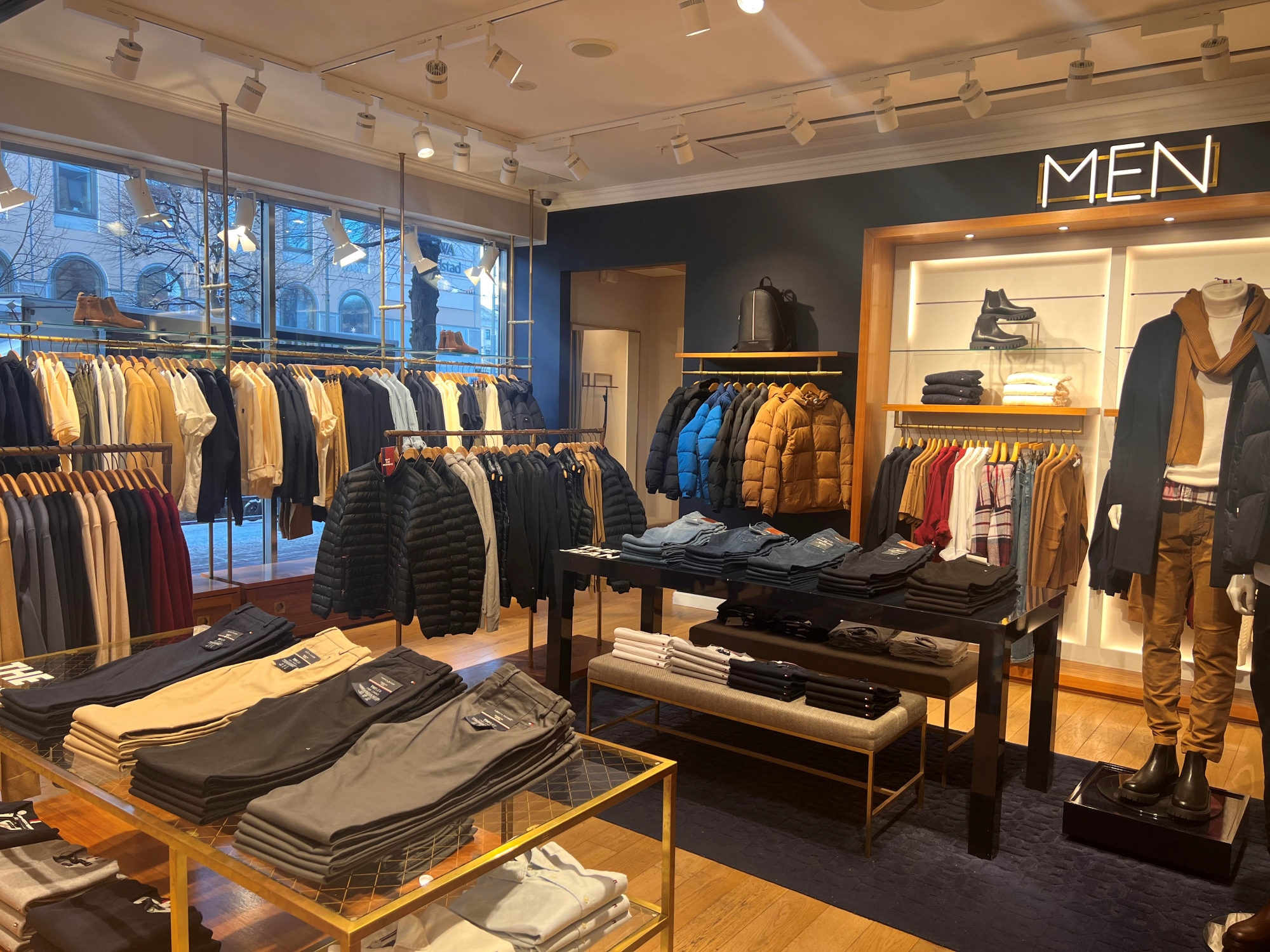Inside of a clothing store where men clothes are displayed.