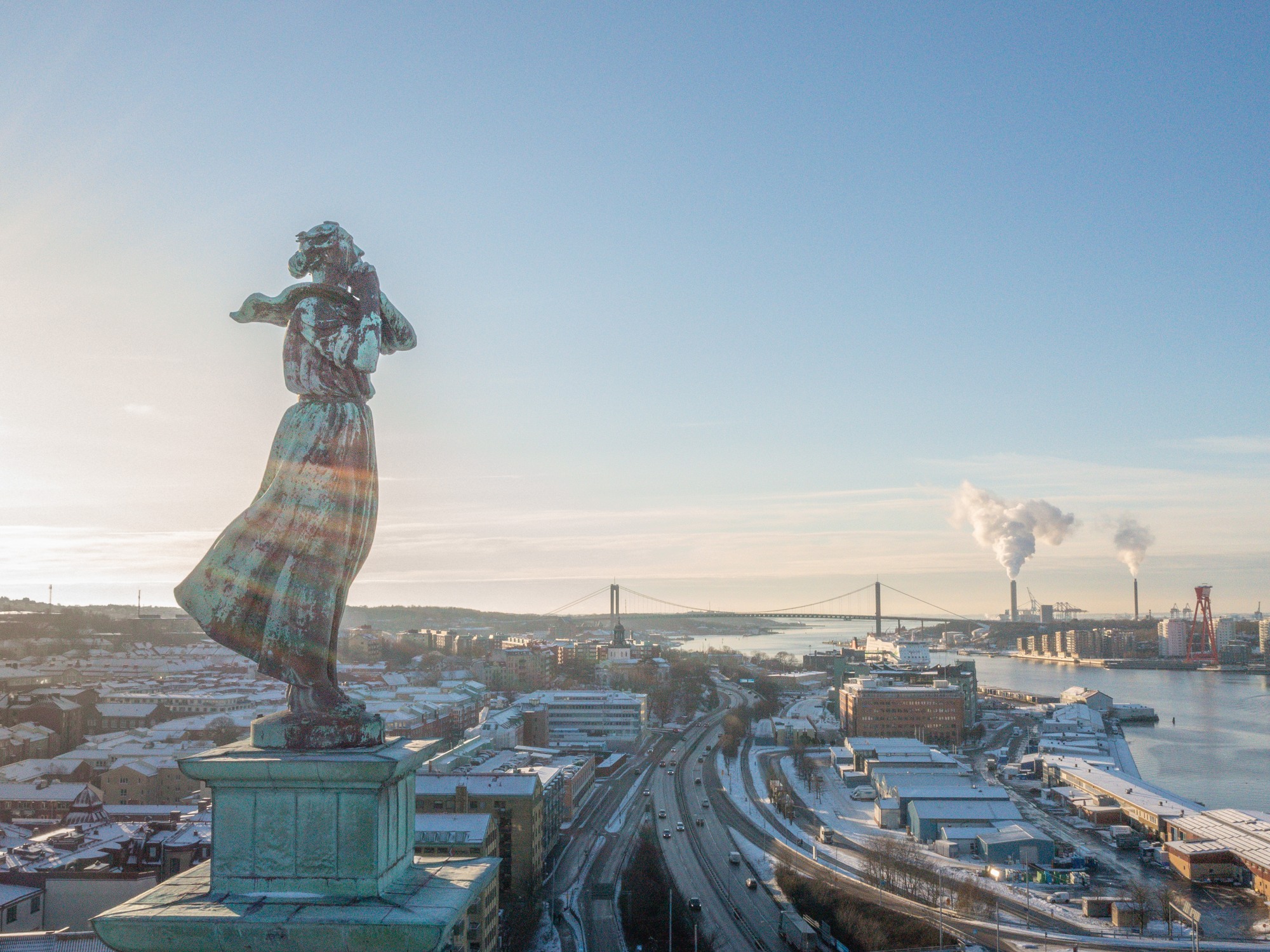 Vybild över Göteborgs hamninlopp med statyn Sjömanshustrun i förgrunden.