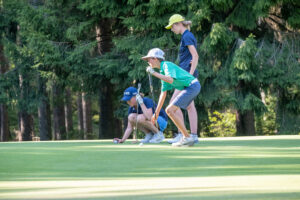 Three young people playing golf.
